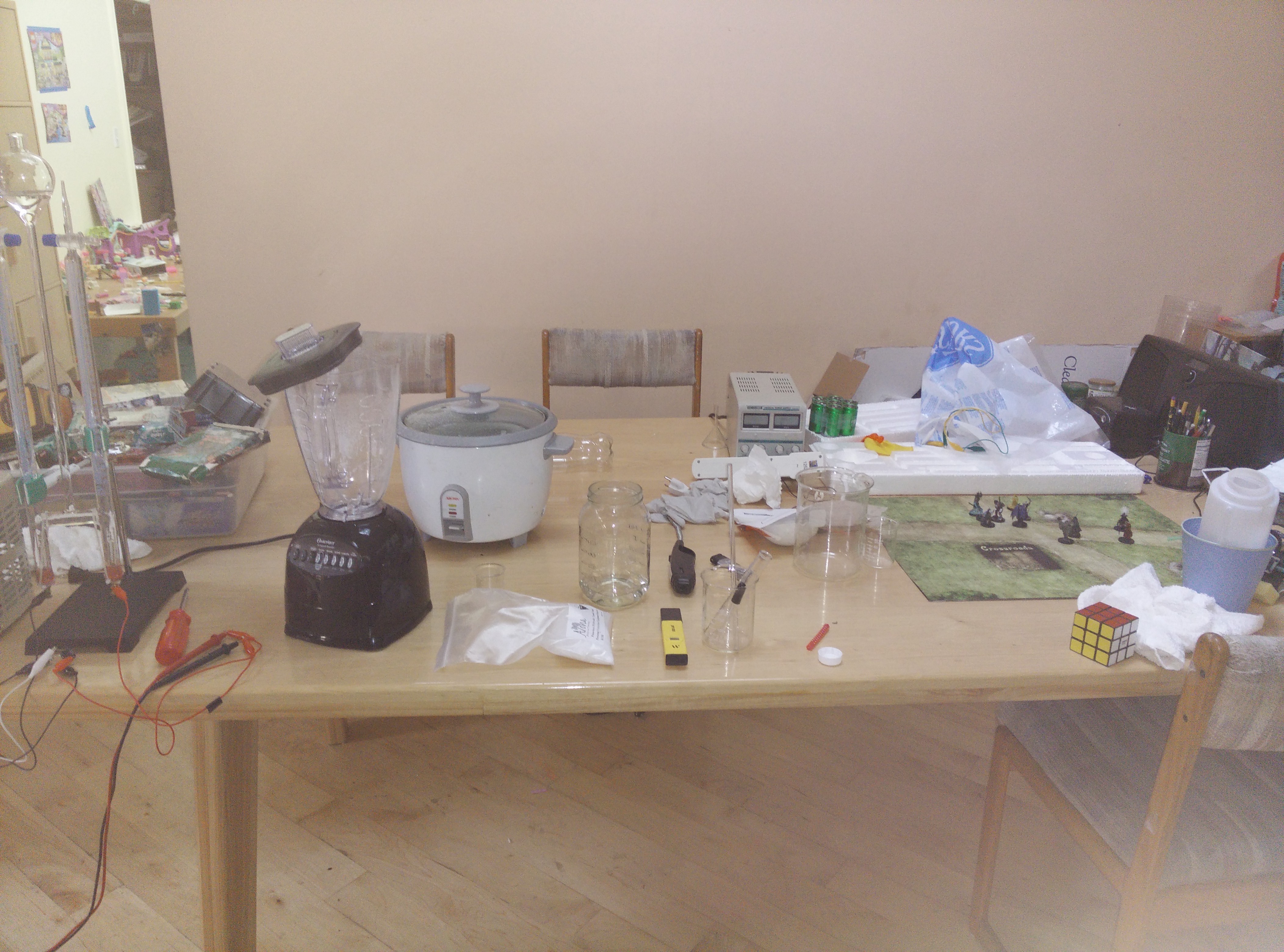 A table in our house full of Dungeons and Dragons, electronics, and chemistry stuff.